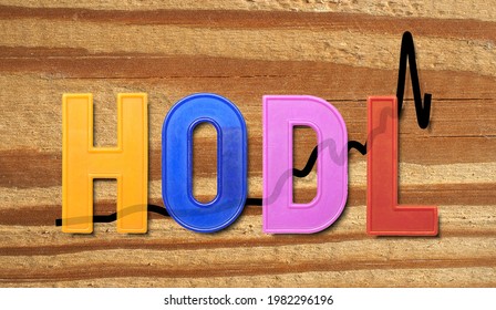 HODL is a term derived from a misspelling of HOLD that refers to buy and hold strategies in the context of cryptocurrencies trading, over wood texture background