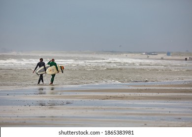 HOEK VAN HOLLAND, THE NETHERLANDS - CIRCA 2019: Surfers Going In The North Sea At The Sandy Beach Of The Hook Of Holland Strand, Popular Recreational Area At The North Sea