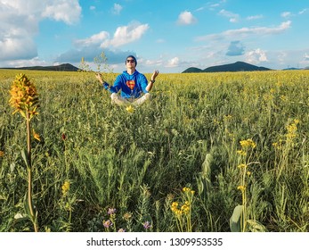 Hohhot, Inner Mongolia / China - 07 11 2017: Man Sitting In High Grass Having A Meditation Session In Inner Mongolia In China, Superpower. Vast Grassland, Yellow Flowers.
