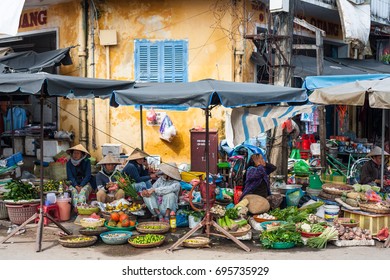 HOI AN, VIETNAM, JANUARY 2: unidentified women with typical vietnamese conical hats sell fresh vegetables on a street market in Hoi An, Vietnam on January 2, 2015.