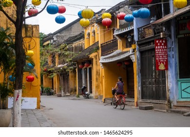 Hoi An, Vietnam - January 2018: Woman Cycling Down Back Street In Hoi An