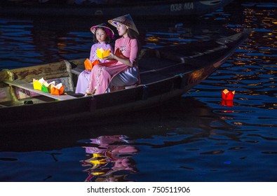 HOI AN , VIETNAM - OCT 04 : Vietnamese mother and daughter holding Lanterns before droping them into the River in Hoi An Vietnam during the Hoi An Full Moon Lantern Festival on October 04 2017 
