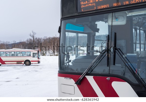 Hokkaido, Japan -\
January 18, 2017: Red Japanese buses parking in white field of snow\
in Asahikawa, Hokkaido,\
Japan.