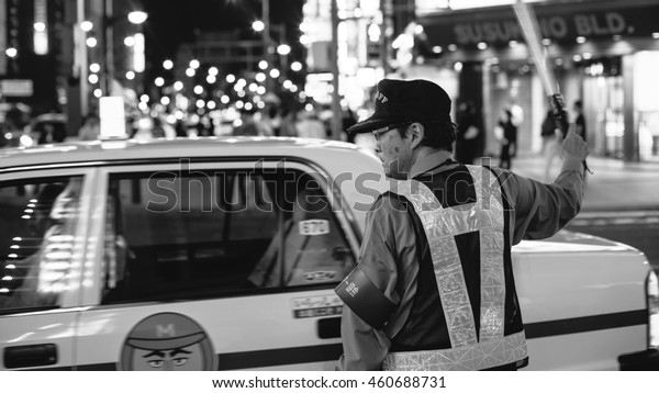 Hokkaido, Japan\
- July 13, 2016 : An Unidentified Policeman works in traffic jam at\
Sapporo in Japan (Black and\
white)