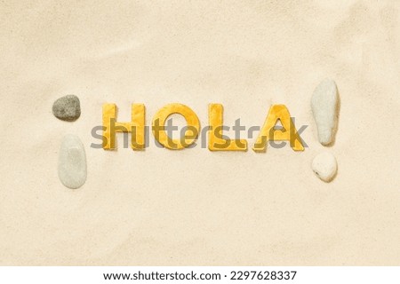 Hola! - Spanish greeting by golden letters in the white sand