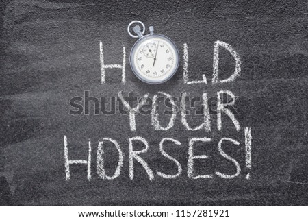 hold your horses exclamation written on chalkboard with vintage stopwatch used instead of O