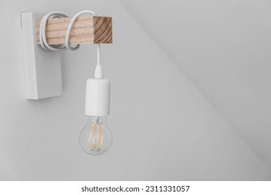 Holder with light bulb on light wall - Powered by Shutterstock