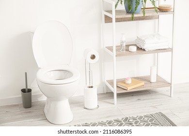 Holder with paper rolls and toilet bowl in restroom