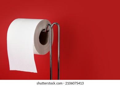 Holder With Toilet Paper Roll On Red Background, Closeup