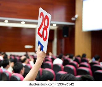 Holding A Auction Paddle