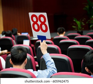 Holding A Auction Paddle