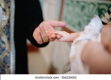 holding baby hand during christening Orthodox baptism