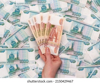 Holding banknotes of five thousand Russian rubles in hand on money background