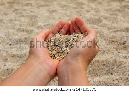 Similar – Beautiful hand holding a stone, on a beach sand background.