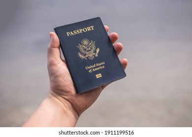 Holding a blue American passport  - Shutterstock ID 1911199516