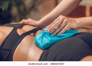 Holding The Blue Ice Pack On The Painful Lower Back.