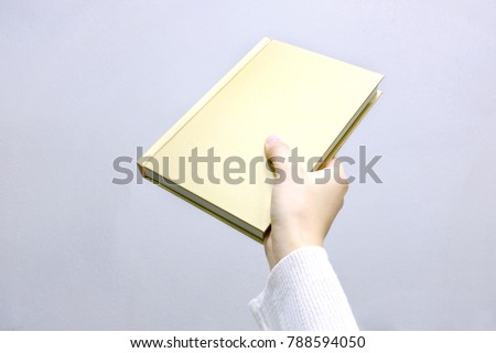 Holding a book by hand