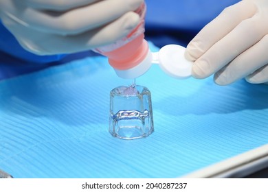 Holding A Bottle Of Fluoride Gel.