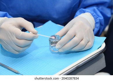 Holding A Bottle Of Fluoride Gel.