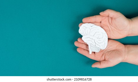 Holding a brain in the hands, Parkinson disease, Alzheimer awardness, mental disorder dementia, psychology problems, cerebral vein thrombosis - Shutterstock ID 2109816728