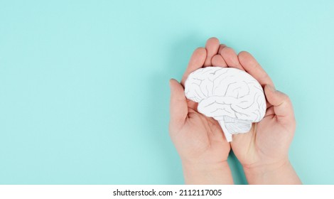 Holding a brain in the hands, Parkinson disease, Alzheimer awardness, mental disorder dementia, psychology problems, cerebral vein thrombosis - Shutterstock ID 2112117005