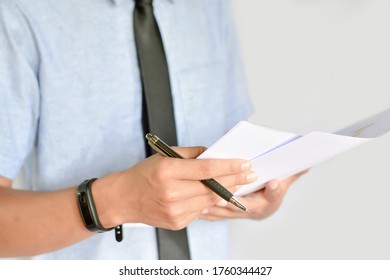 ฺBusinessman is holding a business report paper and a pen / Businessman are analyzing business reports at the office - Shutterstock ID 1760344427