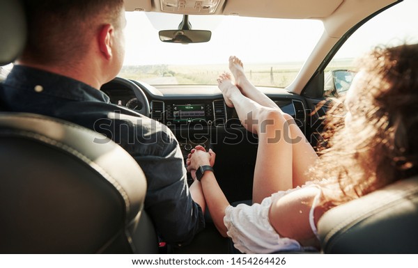 Holding by the hands. Beautiful people is in\
the modern car at their\
weekends.