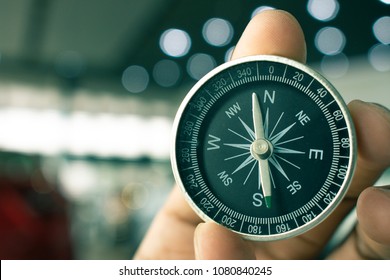 Holding Compass On Blurry Background. Using Wallpaper Or 
Background Travel Or Navigator Image.