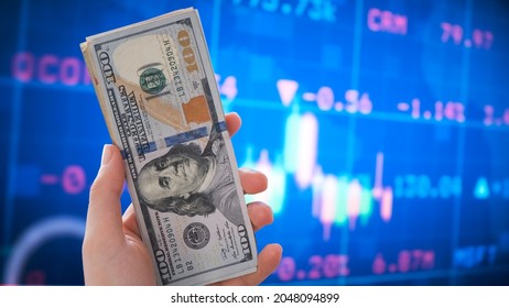 Holding Dollar Bills In The Stock Market. Investors Counting Money After Making It Big On The Stock Market. Becoming Rich And Wealthy. Online Stock Market Information. 