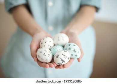 Holding Easter eggs with hand-drawn patterns. Soft calm colors, soft light. Selective focus Easter concept - Powered by Shutterstock