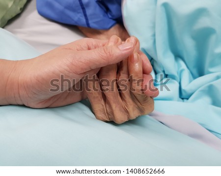 Holding grandmother's hand in the nursing care. Showing all love, empathy, helping and encouragement : healthcare in end of life care and palliative care in hospital concept