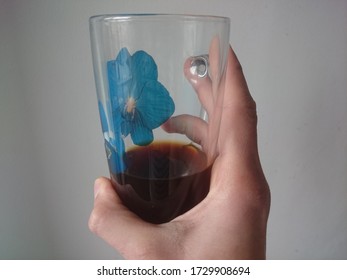 Holding A Half Empty Coffee Mug With Blue Flower Decoration