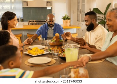 Holding hands, multigenerational family praying before meal at home dining table. tradition, bonding, prayer, faith, togetherness, unity - Powered by Shutterstock