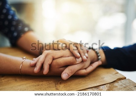 Holding hands, support and comfort of two people talking through a difficult problem. Closeup of friends showing care and love through a hard time, consoling each other and bonding