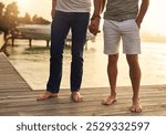 Holding hands, travel and gay couple by pool on vacation, getaway or weekend trip for romance. Love, boardwalk and legs of queer men in relationship with connection, bonding or care at holiday resort