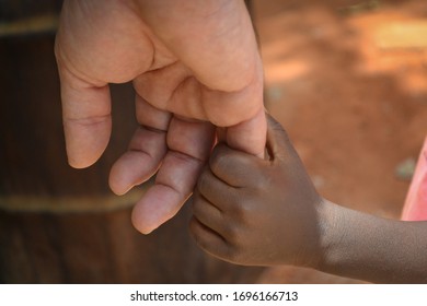 Holding hands white man and black kid - Shutterstock ID 1696166713