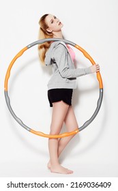 Holding Her Hula Hoop. A Gorgeous Young Woman Holding A Hula Hoop In A Studio Shoot.