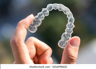 Holding Invisalign Braces On Bokeh Background