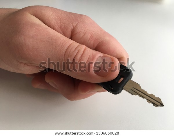 Holding a key in hand\
white background close up Caucasian man door car lock unlock turn\
dead bolt security