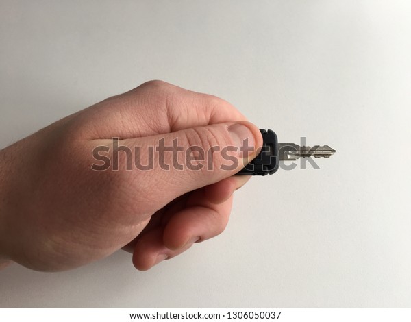 Holding a key in hand\
white background close up Caucasian man door car lock unlock turn\
dead bolt security