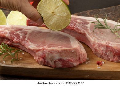 Holding Lemon On Raw Pork Prime Rib. Selective Focus