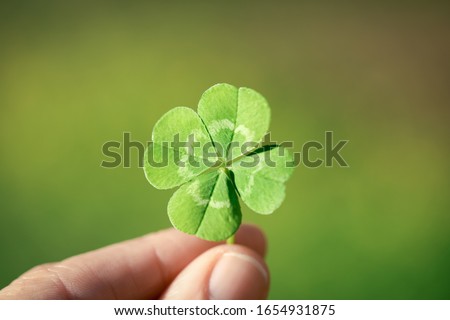 Holding a lucky four leaf clover.
