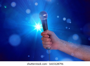 Holding a microphone on stage