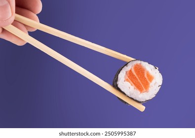 Holding piece of urumaki sushi roll with chopsticks isolated - Powered by Shutterstock