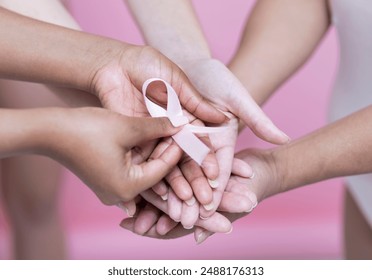 Close-up?of?women''s?hands holding pink breast cancer awareness ribbon - Powered by Shutterstock