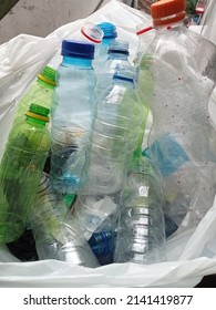 Holding Plastic Bottles To Throw In White Garbage Bags, Waste Management And Plastic Recycling Concept.collect Plastic Bottles Into Plastic Bags For Recycling. Save Earth. Recyle, Reuse