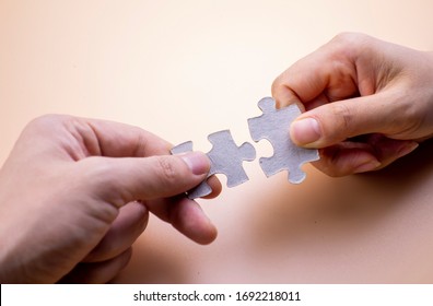 Holding the puzzle in one's hand against a solid background - Shutterstock ID 1692218011