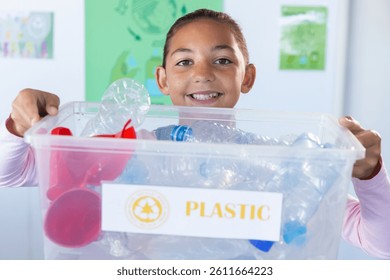 Holding recycling bin, smiling girl participating in school recycling program. sustainability, environment, eco-friendly, participation, education, community