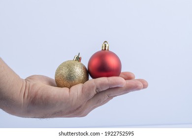 Holding red and golden glittering balls in the hand