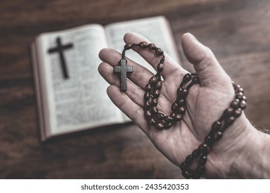 Holding Rosary Beads and Holy Bible in church concept for faith, spirtuality and religion - Powered by Shutterstock